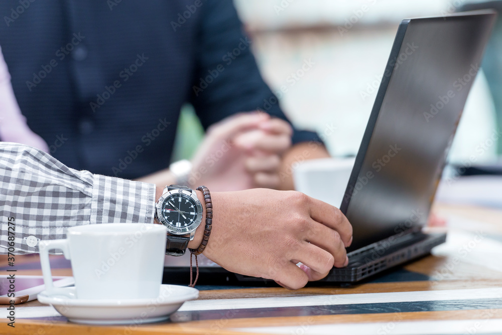 Businessman with a laptop on his desk discussing business Businessman with a laptop on his desk discussing business
