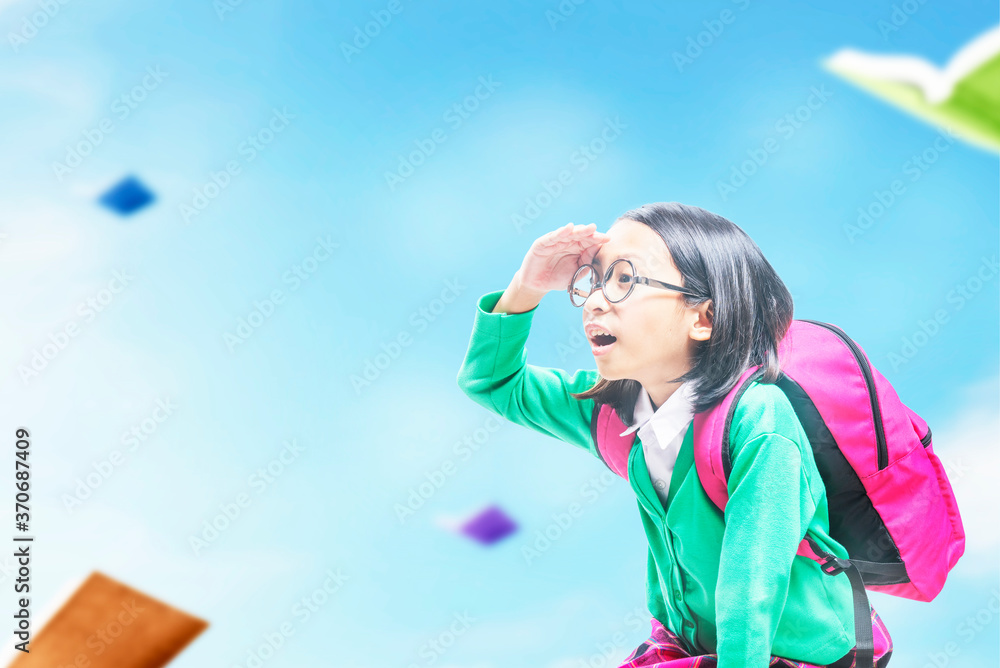 Asian little girl with a backpack flying on the book to back to the school Asian little girl with a backpack flying on the book to back to the school