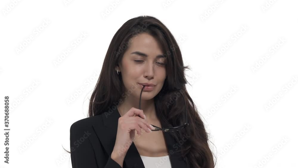 Portrait of Caucasian woman in formal jacket, touching her lips by glasses temples. Posing for camera. Sexy office worker. Isolated on white background Portrait of Caucasian woman in formal jacket, touching her lips by glasses temples. Posing for camera. Sexy office worker. Isolated on white background