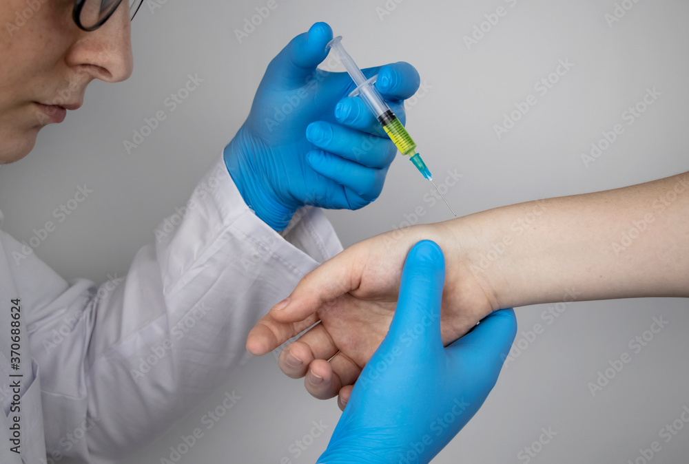 An orthopedic surgeon gives an injection in the wrist. Treatment of osteoarthritis with hormonal drugs or drugs based on hyaluronic acid. Help with diseases that damage the cartilage of the joint An orthopedic surgeon gives an injection in the wrist. Treatment of osteoarthritis with hormonal drugs or drugs based on hyaluronic acid. Help with diseases that damage the cartilage of the joint