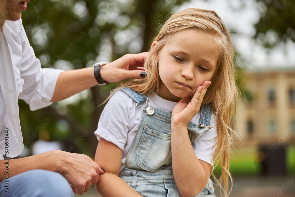 Female child holding hand on the face while feeling pain in the teeth Female child holding hand on the face while feeling pain in the teeth