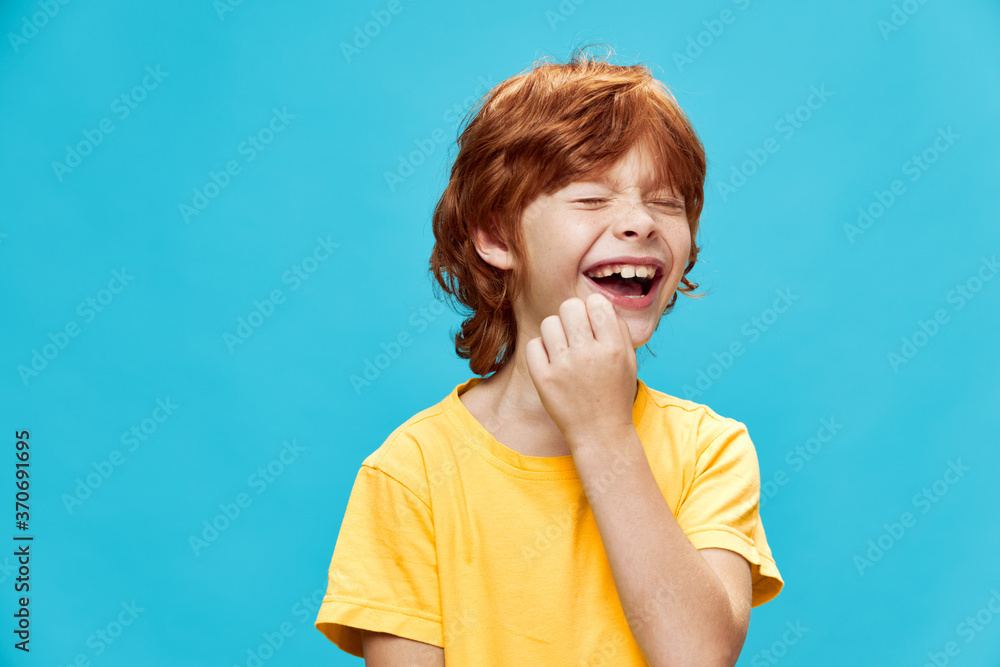 Funny boy in a yellow T-shirt with red hair 