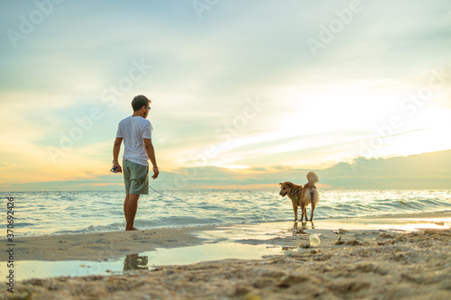 A man and a dog on the beach.