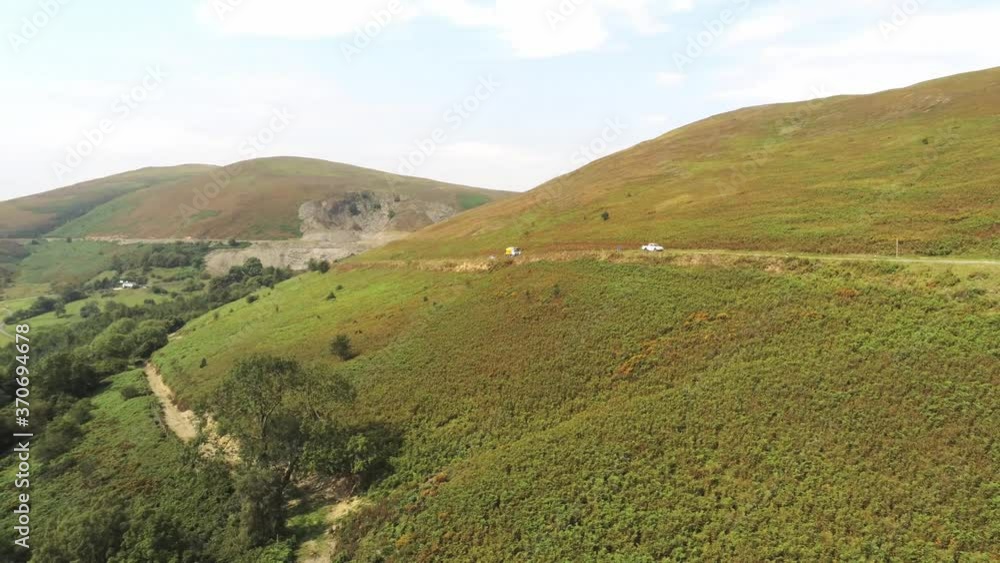 Aerial view traffic driving on Horseshoe pass lush scenic misty mountain valley picturesque rural countryside Aerial view traffic driving on Horseshoe pass lush scenic misty mountain valley picturesque rural countryside