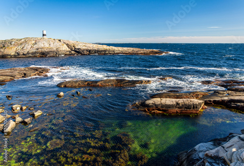 Swedish sea bay with old lighthouse photo