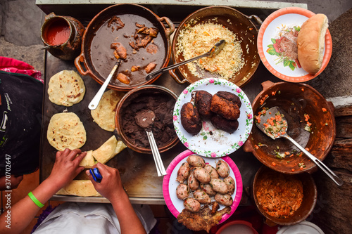 Unrecognizable woman hands cooking over counter full of traditional Guatemalan foods photo