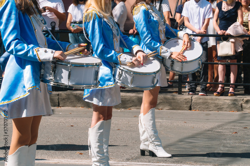 Majorettes and marching band. Young girls drummer at the parade. Street performance