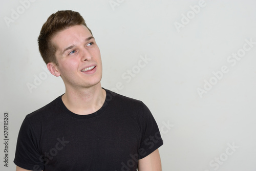 Portrait of happy young handsome man against white background © Ranta Images