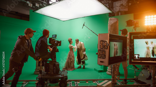 On Set: Famous Female Director Controls Cameraman Shooting Green Screen Scene with Two Actors Talented Wearing Renaissance Clothes Talking. Crew Shooting Period Costume Drama Movie.