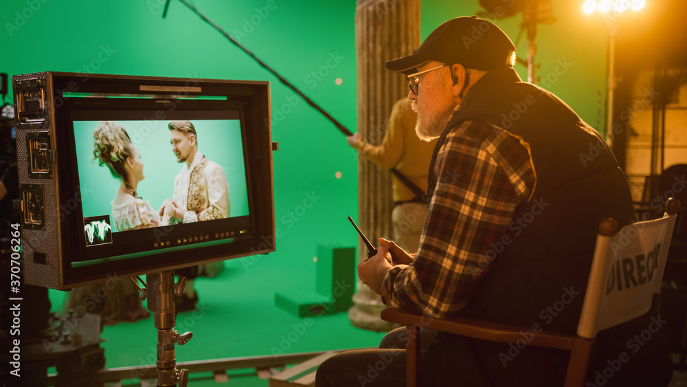 Director Looks at Display Controls Shooting Period Drama Movie. Green Screen CGI Scene with Actors Wearing Renaissance Costumes. Crew Shooting High Budget Movie. Side View