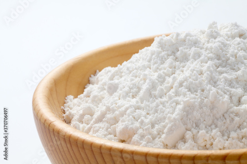 wheat flour in a wooden bowl isolated on white background. close-up.