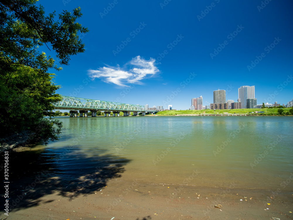 青空の広がる荒川と埼玉県川口市の風景。8月。