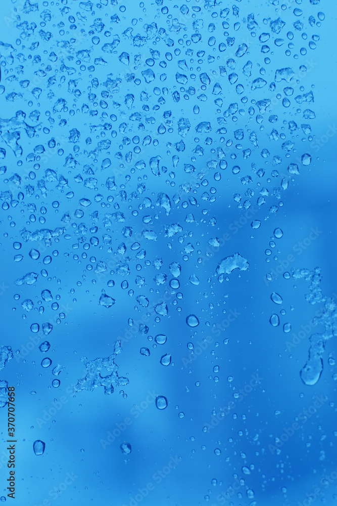 Blue background with droplets on a transparent surface.
