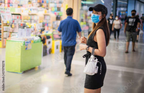Shallow depth of field Asian woman wear medical face mask walking in shopping mall, Asia people wearing facemark during coronavirus in public space mall, Virus and illness protection