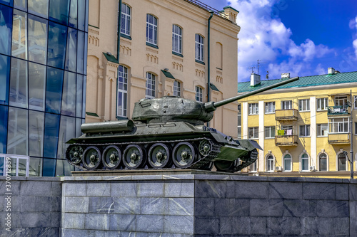 Kharkiv, Ukraine - July 20, 2020: A T-34-85 tank on display at M.F. Sumtsov Kharkiv Historical Museum, outdoors. Soviet medium tank of the World War II against  of city buildings on a summer day photo