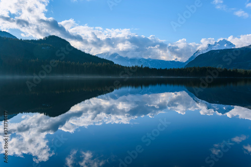 Beautiful blue lake with surrounding mountains reflecting back