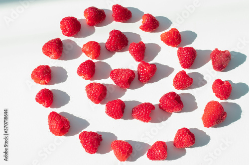  Raspberries on a white plate and with mint in the middle.