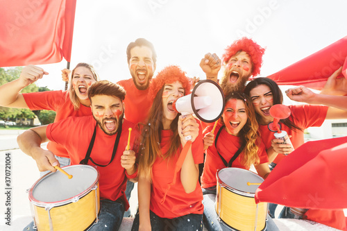 Friends football fans watching soccer match event at stadium - Young people having fun supporting club on sport world championship - Spectators entertainment lifestyle concept