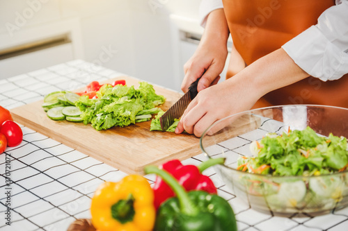 Vegetarian woman Chopping food ingredients vegetable salad while cooking in kitchen