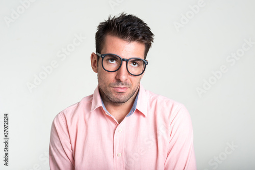 Portrait of young handsome Hispanic businessman against white background © Ranta Images