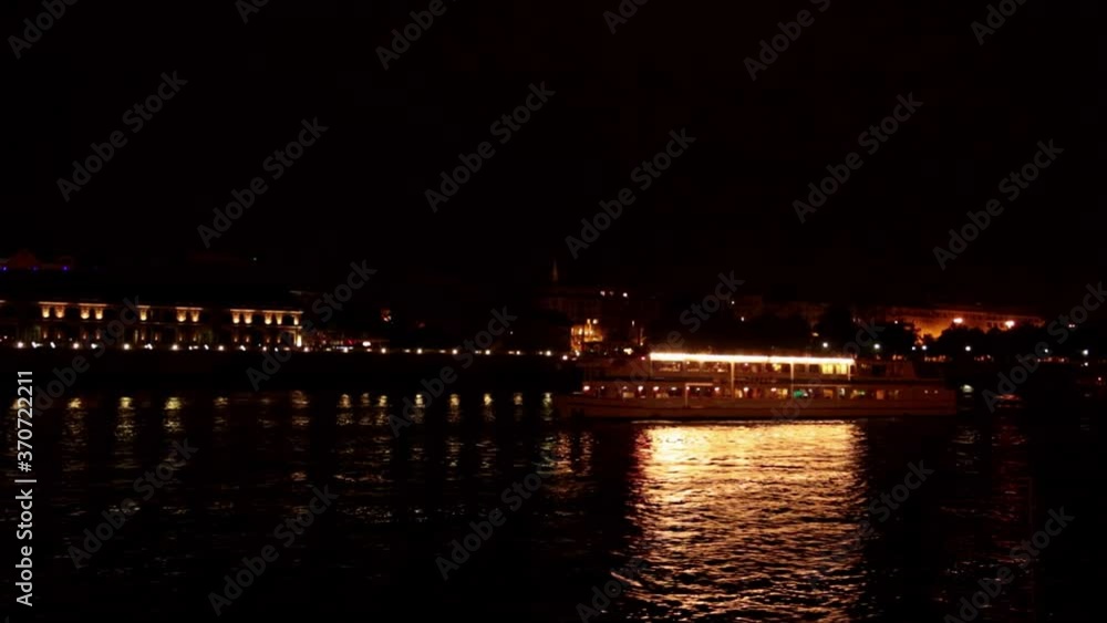 A boat passes under Bridge aser show on the Danube River A boat passes under Bridge aser show on the Danube River