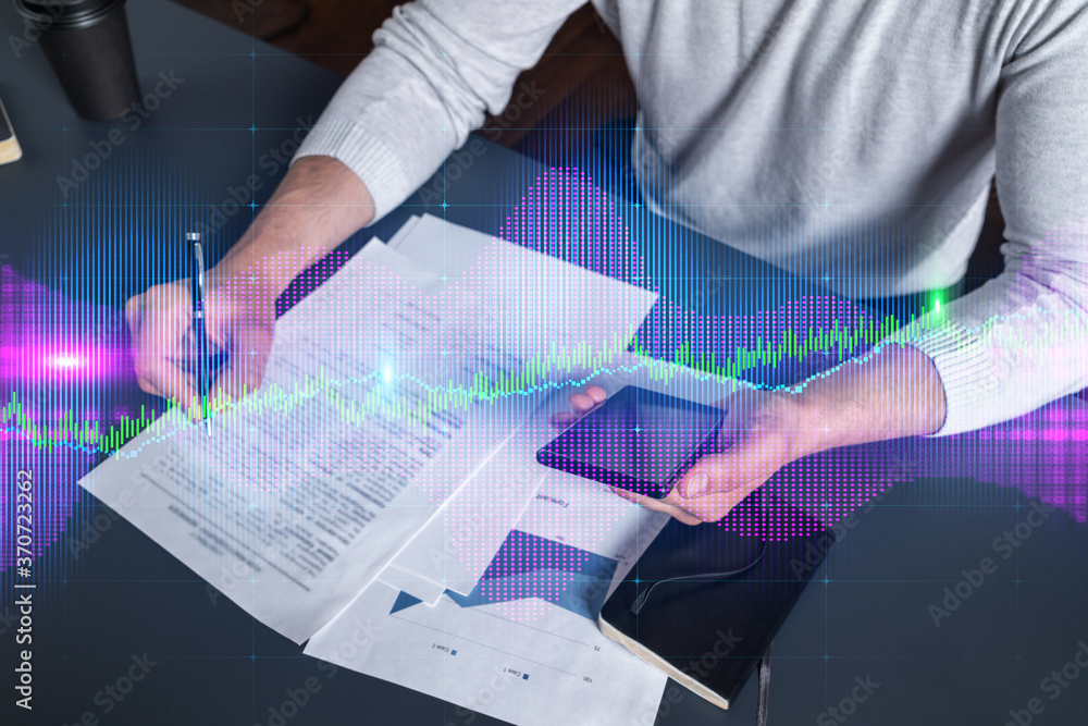 Multi exposure of man signing contract with phone and forex chart hologram. Concept of financial market, stock exchange, investment in bonds. Multi exposure of man signing contract with phone and forex chart hologram. Concept of financial market, stock exchange, investment in bonds.