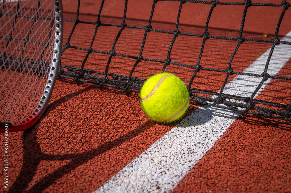 Shadow of net and racket surrounding a tennis ball