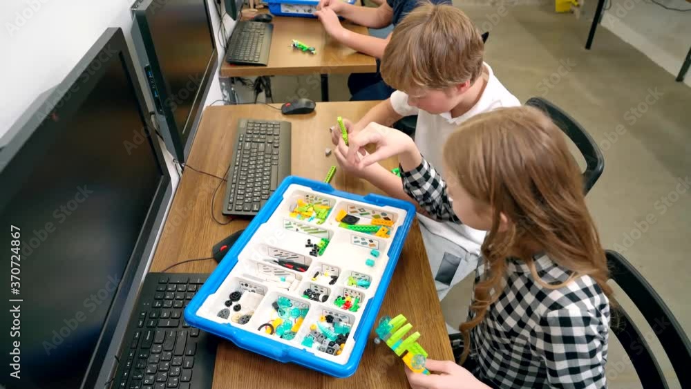 Kids making robot using building kit. Kids making robot using building kit.