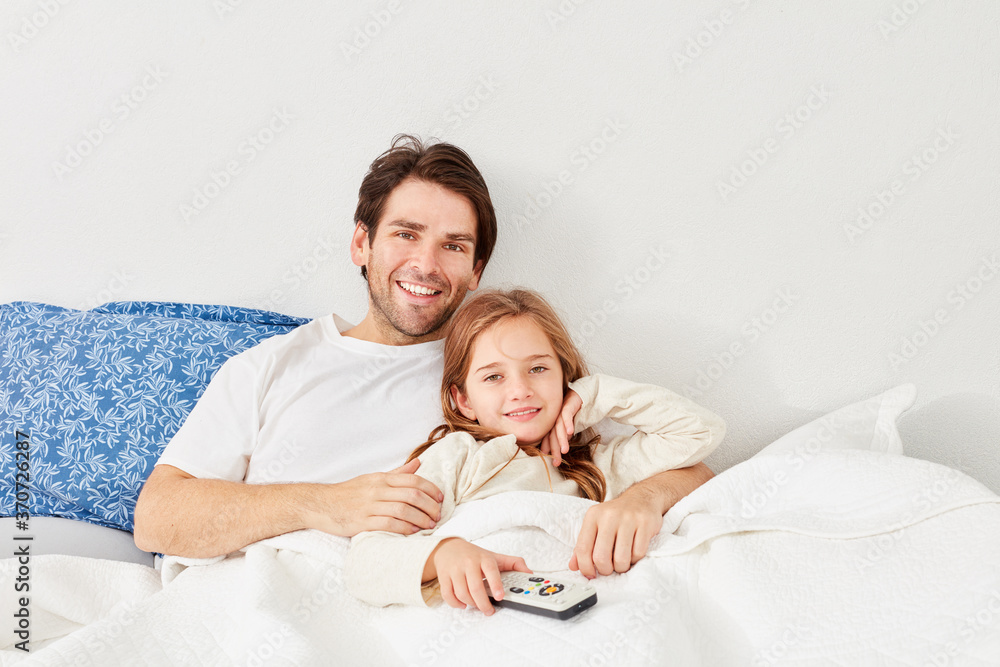 Glückliches Mädchen im Bett mit Fernbedienung Glückliches Mädchen im Bett mit Fernbedienung