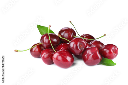 Fotografija Tasty ripe red cherries with green leaves isolated on white