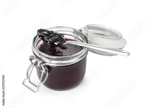Spoon and jar of blueberry jam isolated on white
