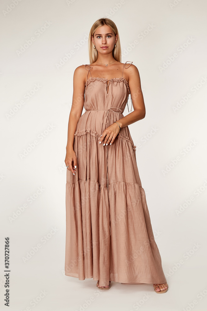 Pretty beautiful sexy elegance woman skin tan body fashion model glamor pose wear long beige silk trend dress party summer collection makeup hair style blond success jewelry studio. Pretty beautiful sexy elegance woman skin tan body fashion model glamor pose wear long beige silk trend dress party summer collection makeup hair style blond success jewelry studio.