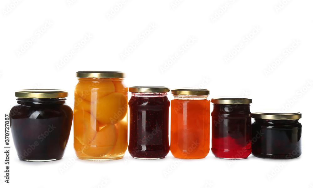 Glass jars with different pickled fruits and jams on white background Glass jars with different pickled fruits and jams on white background