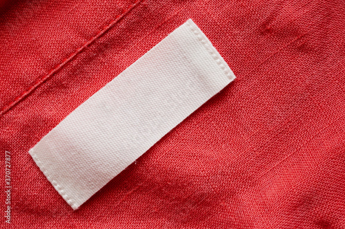 Blank clothing tag label on linen shirt fabric texture background
