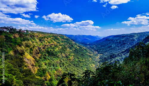 The green valley formed by the mighty mountains of Sahyadri range and clear blue skies.