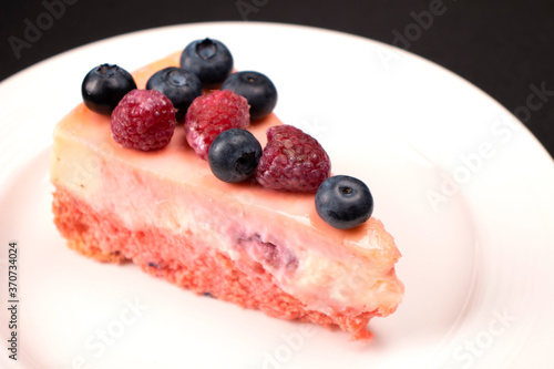 Cheesecake with berries on a white plate. Concept food photography. Sweets and berries. Copy space.
