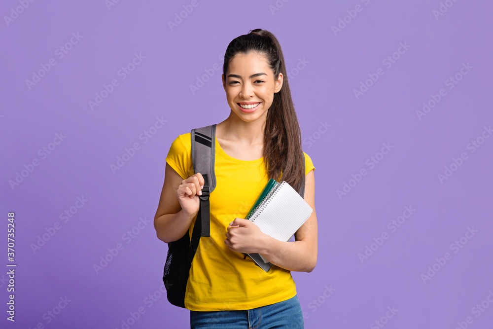 Education Concept. Asian student girl with workbooks and backpack smiling to camera Education Concept. Asian student girl with workbooks and backpack smiling to camera
