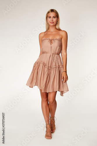 Canvas Print Beautiful woman fashion model makeup blond hair perfect body shape tanned skin wear clothes summer collection organic short beige silk dress stylish sandals shoes, accessory jewelry earrings date