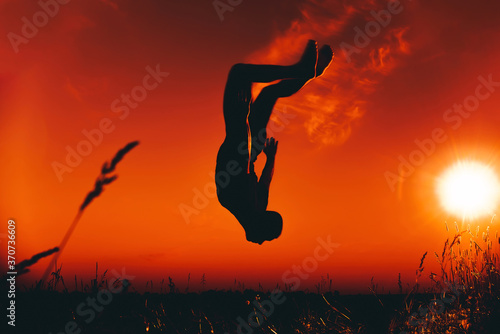 silhouette of a male athlete jumping and doing somersaults