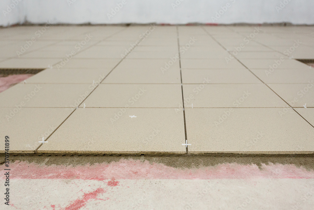 Fototapeta premium Fragment of the floor, in the process of laying ceramic tiles.