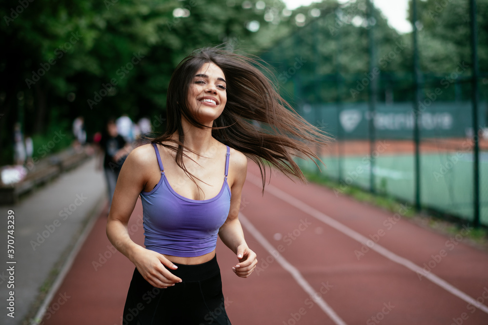 Happy athletic woman running in nature in the morning. Young woman training outdoors.