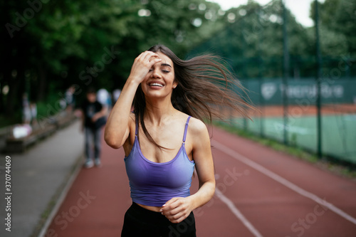 Happy athletic woman running in nature in the morning. Young woman training outdoors. © JustLife
