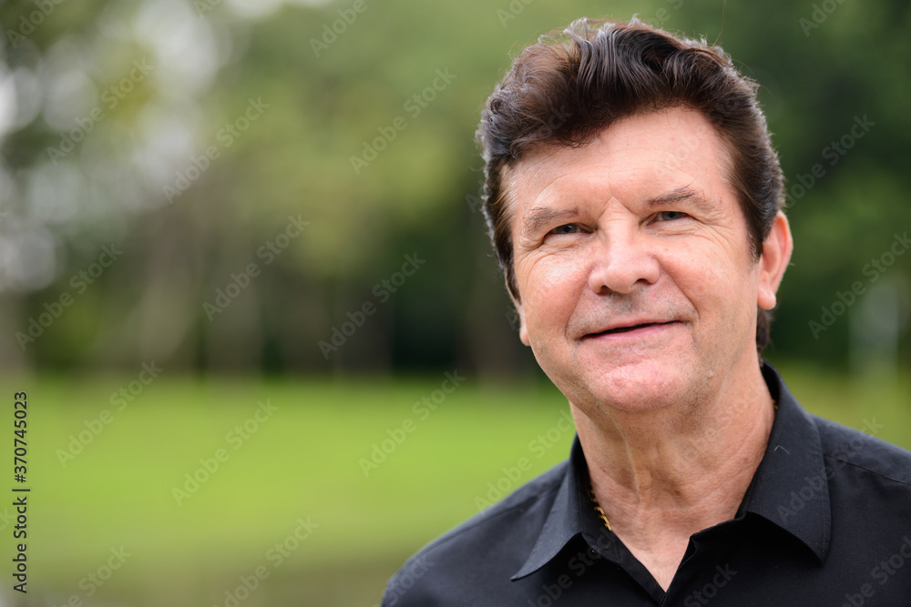 Portrait of happy mature handsome businessman relaxing at the park Portrait of happy mature handsome businessman relaxing at the park