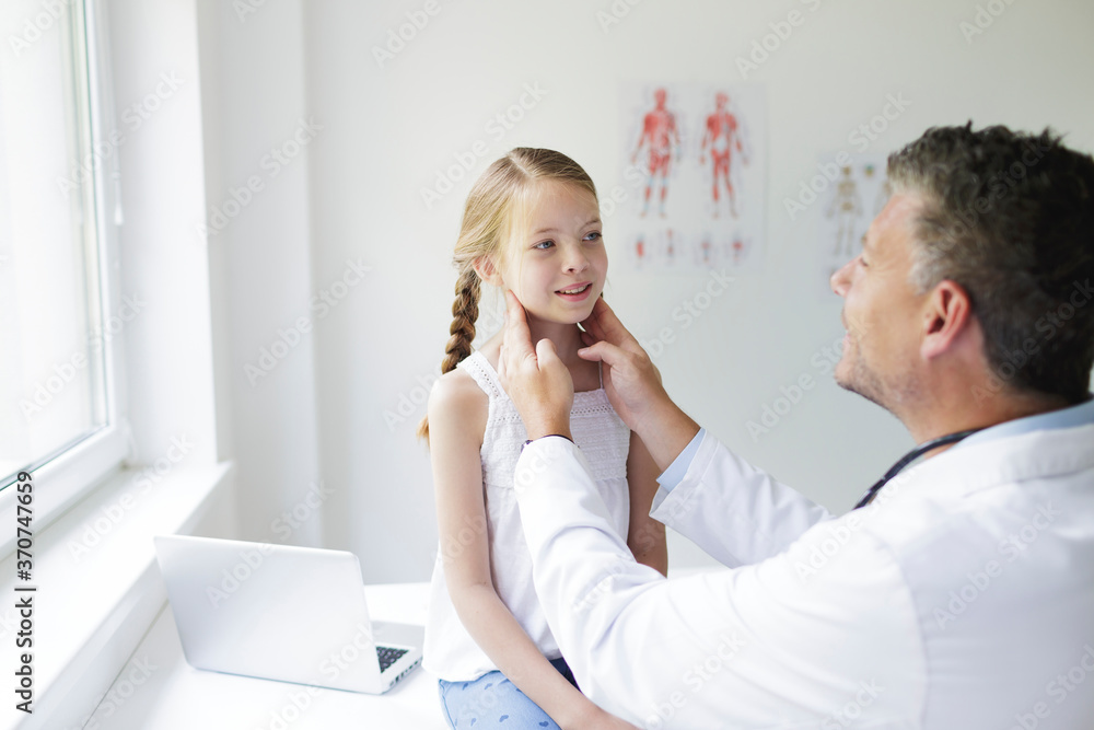 Doctor in white coat examines young, pretty girl in his practice or in a hospital Doctor in white coat examines young, pretty girl in his practice or in a hospital