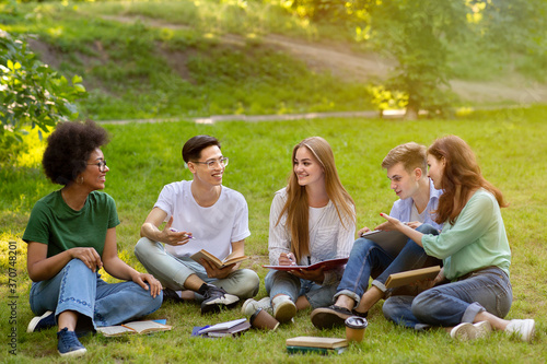 Happy multiracial students resting and preparing for exams outdoors at campus © Prostock-studio