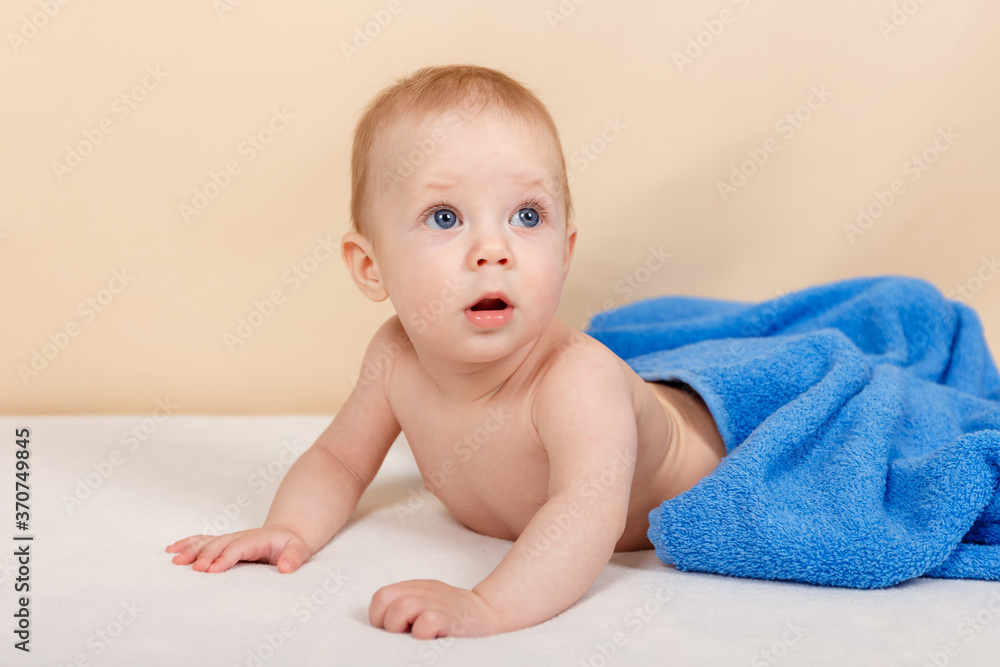 Adorable baby boy lying under the towel and having fun after bath Adorable baby boy lying under the towel and having fun after bath