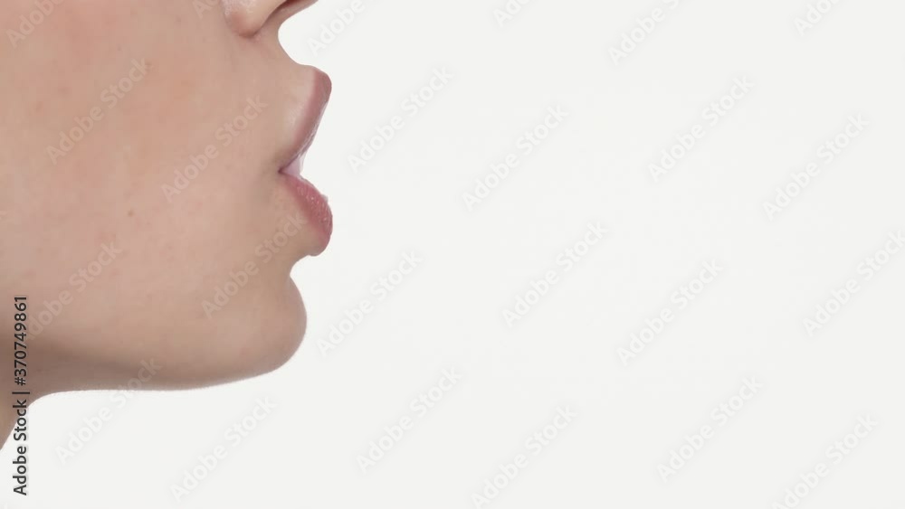 Macro shot of lower face of Caucasian woman chewing bubble gum and blowing balloon. Side view. Copy space Macro shot of lower face of Caucasian woman chewing bubble gum and blowing balloon. Side view. Copy space