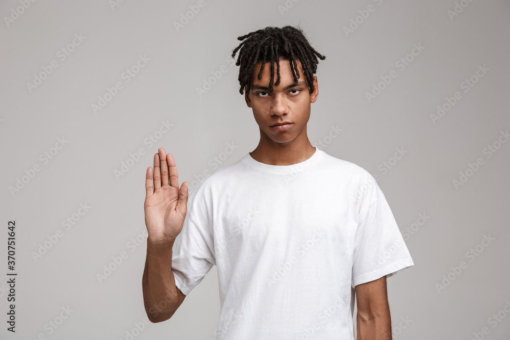Serious young man showing stop gesture isolated Serious young man showing stop gesture isolated