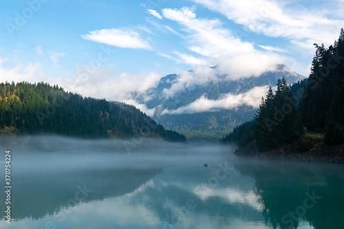 Lake with mountain fog and mist with clouds in Northern Cascades Pacific Mountain Range National Park Washington, USA