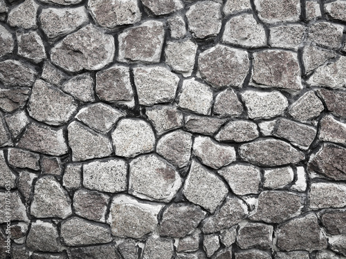 Abstract background of the old wall of black natural stone with cracks and scratches. Landscape style. Great background or texture.